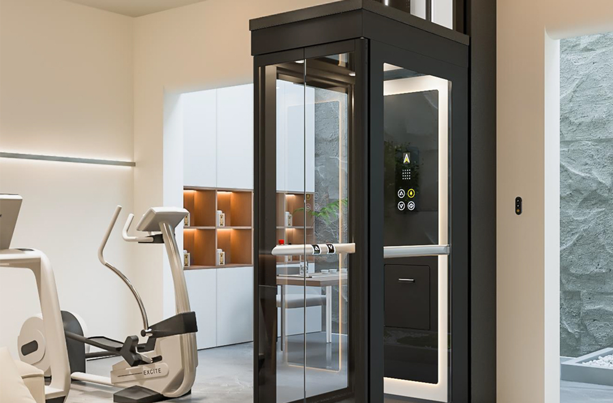 Ascenda: Mini Elevator with black frame and glass shaft installed beside home gym equipment, door open and handrail control visible.