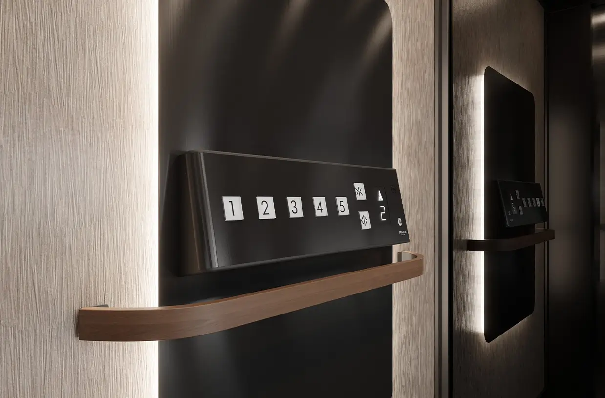Close-up view of the Gravital Essence home lift control panel, featuring illuminated floor buttons 1 to 5 on a sleek black panel with soft backlighting and a curved wooden handrail.
