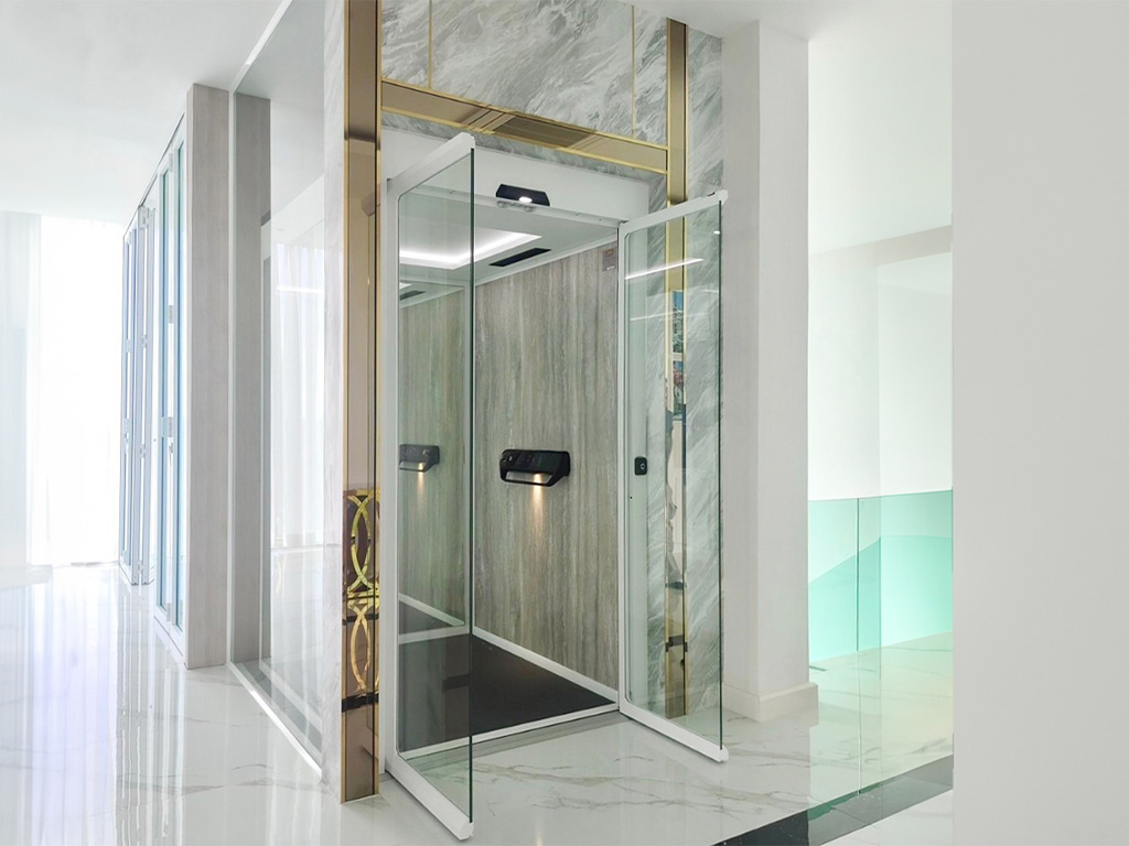 Cibes V70 cabin lift, Aurora tier, HPL wall panels, glass doors, installed in a marble-clad existing shaft.