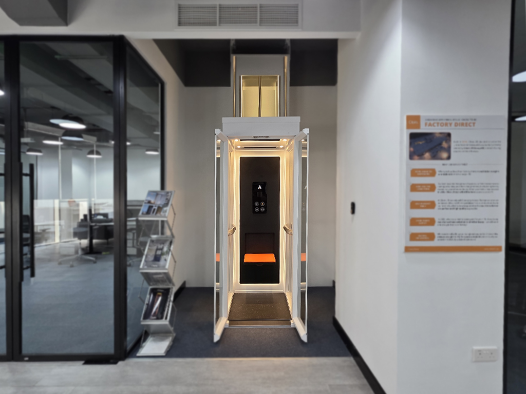 Cibes Ascenda mini home lift on display in the Dubai showroom, doors open with warm cabin lighting.
