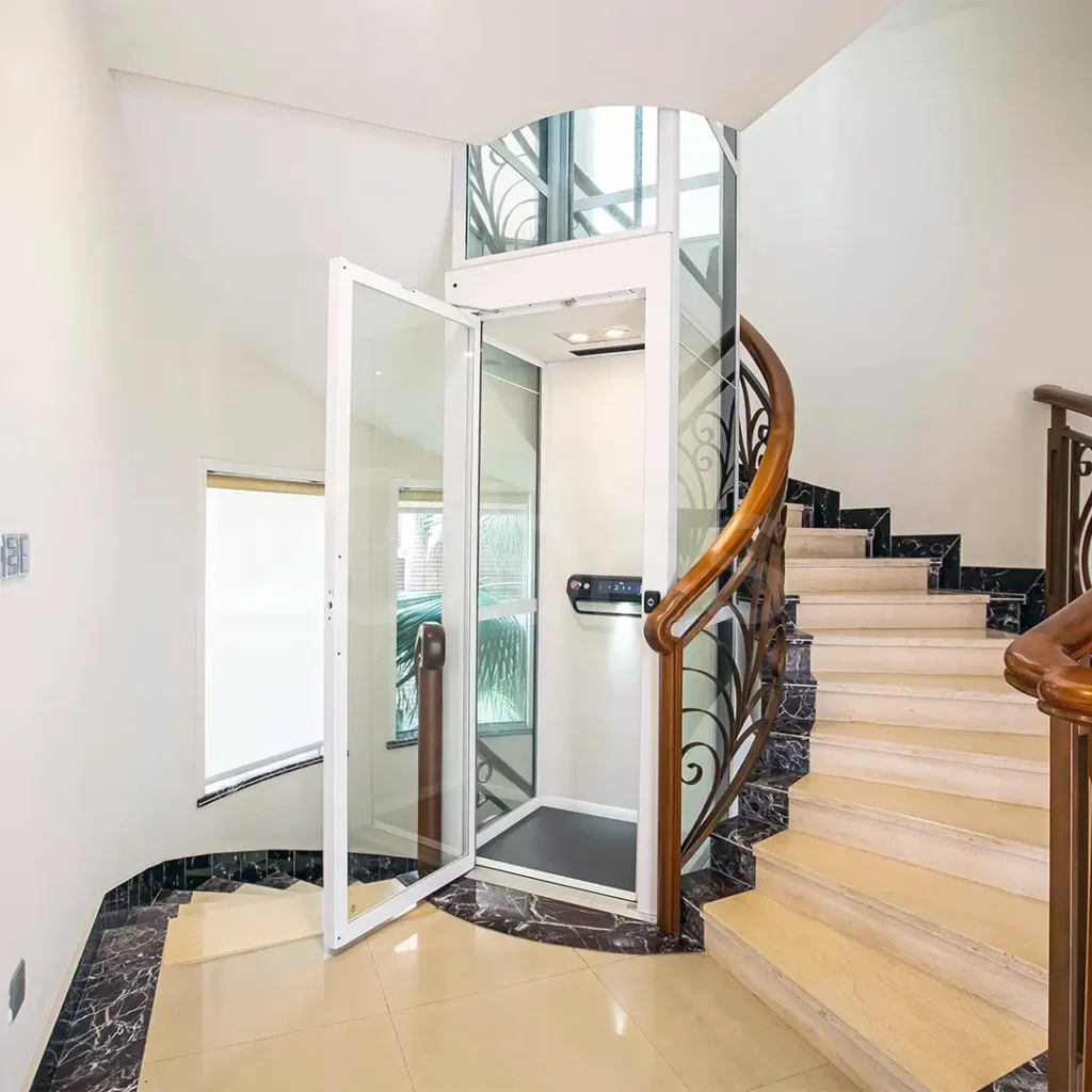 Cibes V90 home lift installed in a curved staircase with glass shaft and white frame.