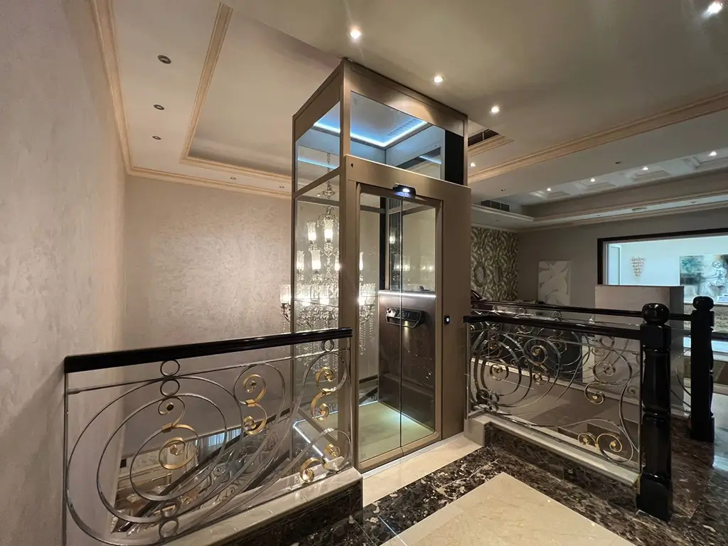 EN 81-41 compliant platform home lift installed in a private residence, featuring an enclosed glass structure and safety-controlled landing access.